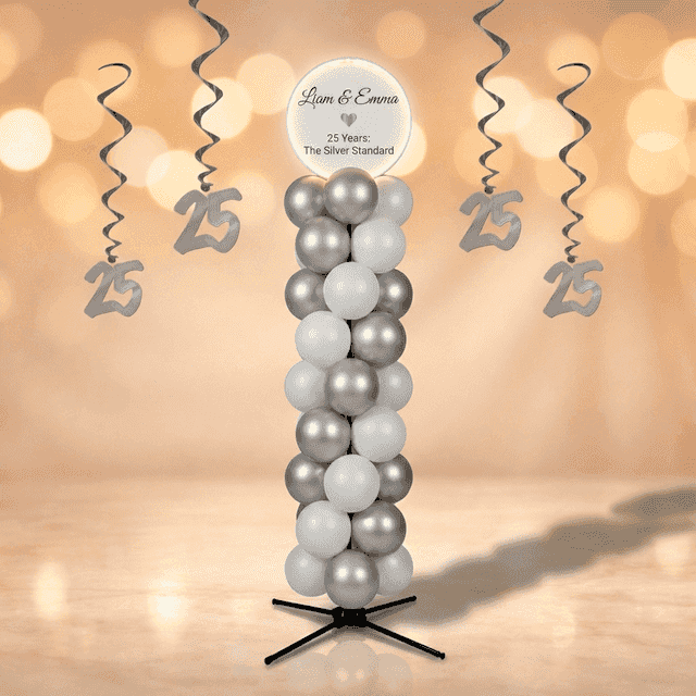 Colonne de ballons argent et blanc avec panneau rond blanc portant les noms du couple, dans une salle de fête dorée avec lustres en cristal