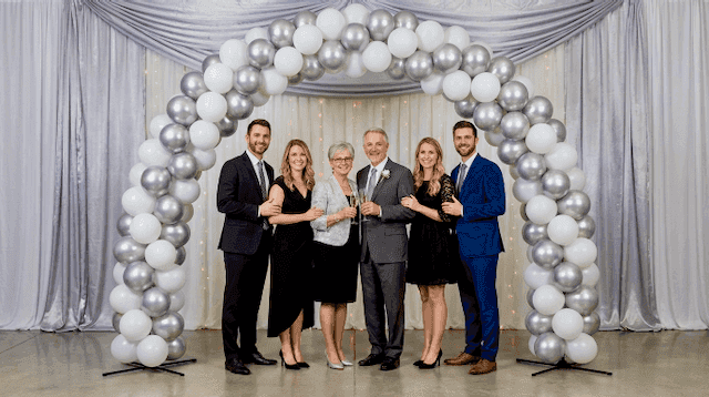 Arche de ballons argentée et blanche comme photomur lors d'une fête festive de 25 ans de mariage