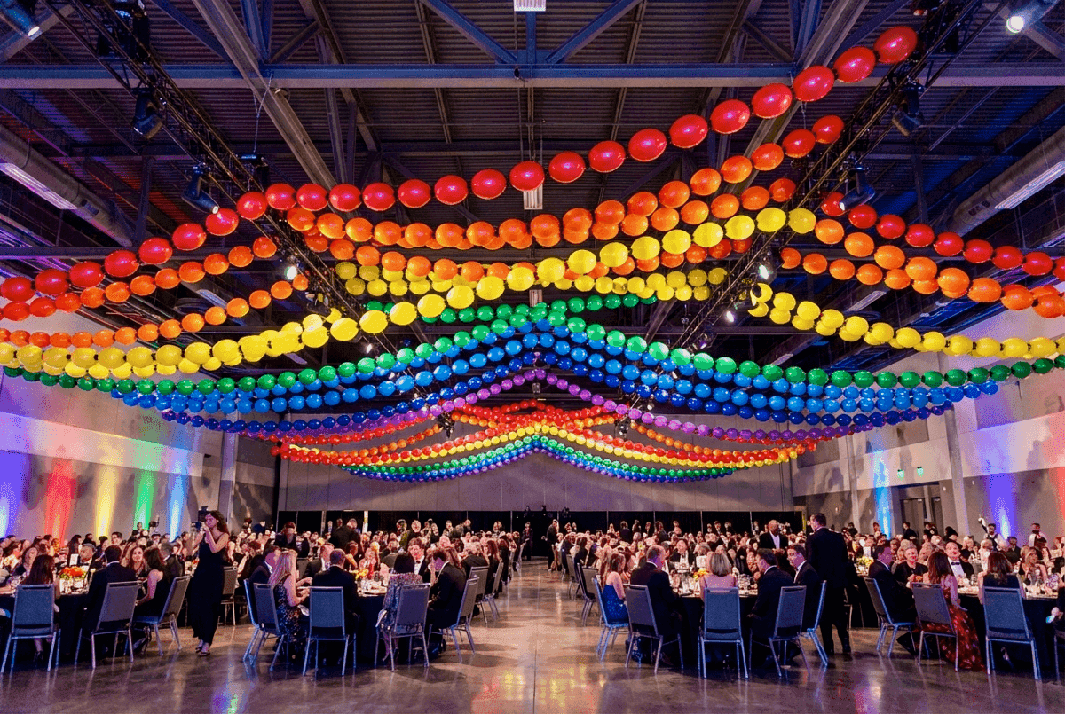 Longue guirlande de ballons arc-en-ciel au-dessus d'un site de festival
