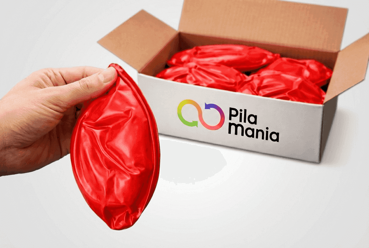 Main tenant une balle PVC vide au-dessus d'une boîte contenant plusieurs balles plates