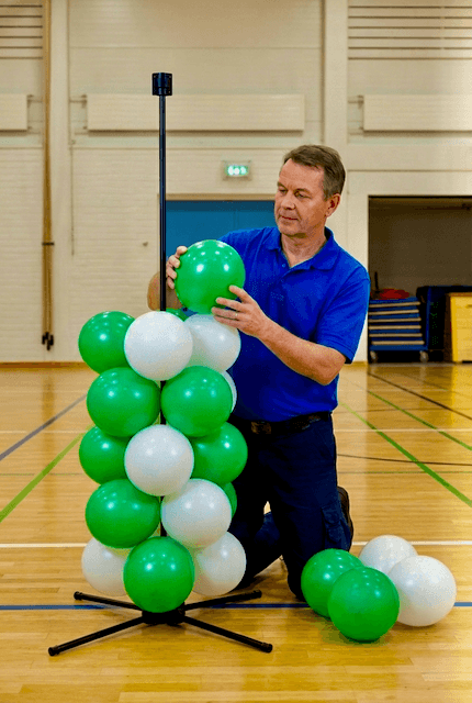 Personnel scolaire montant la décoration PilaMania en ballons pour la remise des diplômes de manière autonome