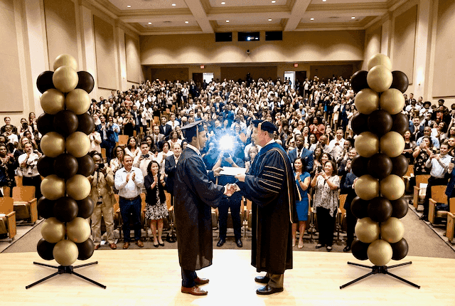 Colonnes de ballons élégantes en teintes neutres lors d'une cérémonie de remise des diplômes universitaire